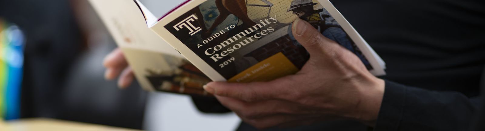 A community member studies a Temple guide to community resources.