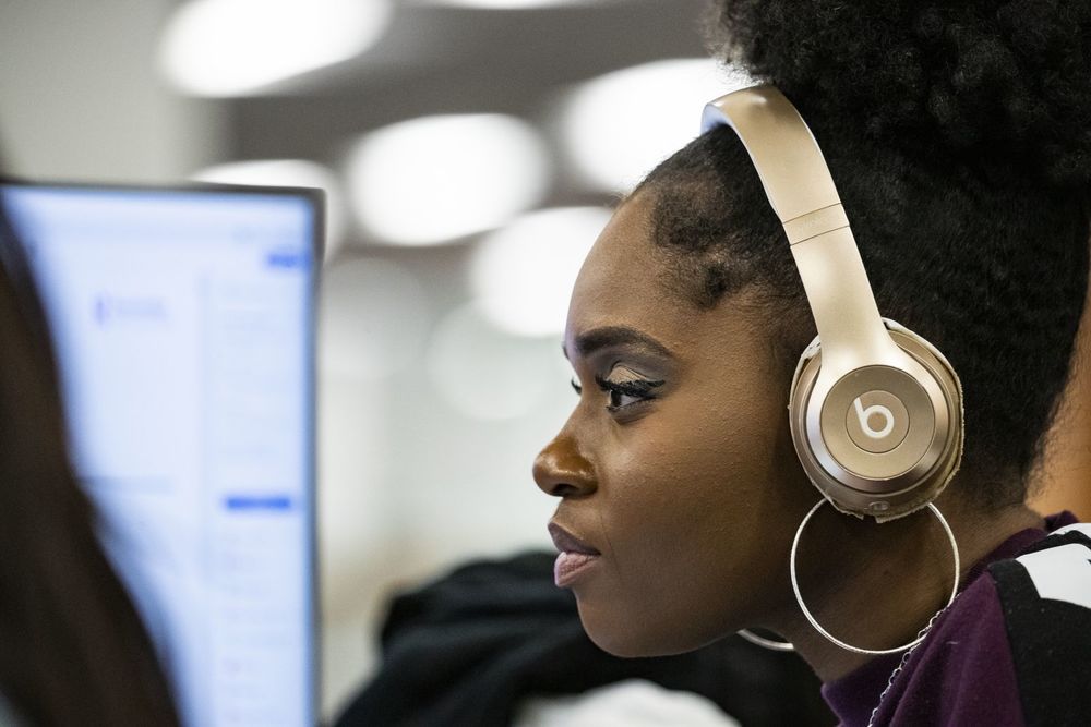 A Temple student peers closely at the monitor as they work in the computer lab.